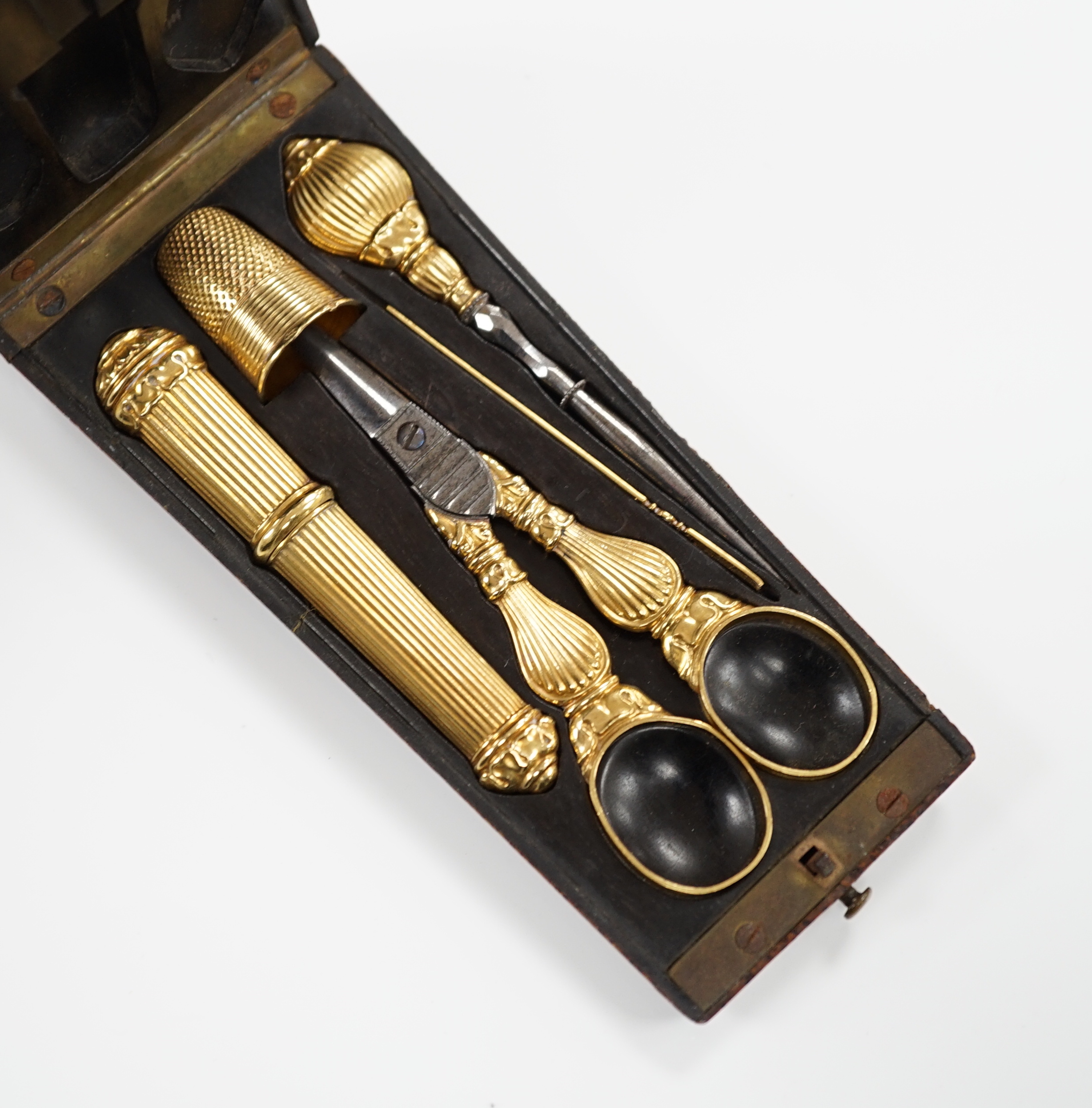 A 19th century French yellow metal (18ct poincon mark) necessaire, comprising a thimble, needle case, mounted steel scissors and mounted threader, in original leather mounted fitted case.